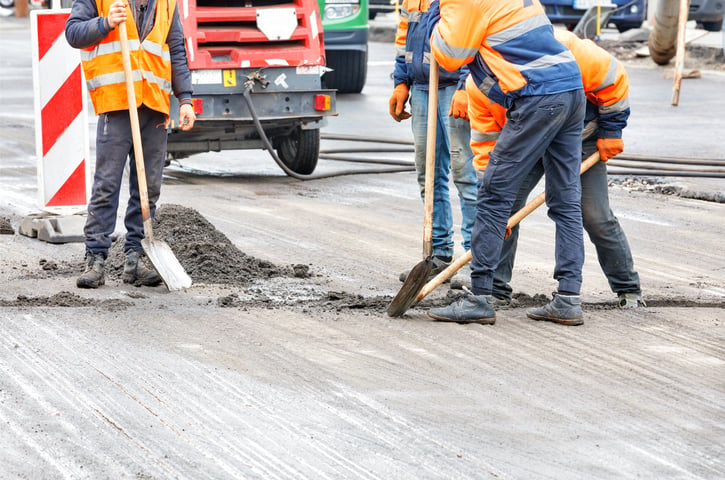 workers spreading concrete at a construction site, getting the job done faster with e-ticket solutions over a paper ticket system