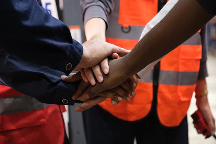 diverse team of fleet drivers bringing hands in to represent teamwork