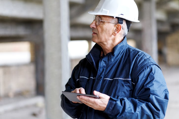 senior construction manager controlling building site using digital tablet with robust data security measures and security measures in the software